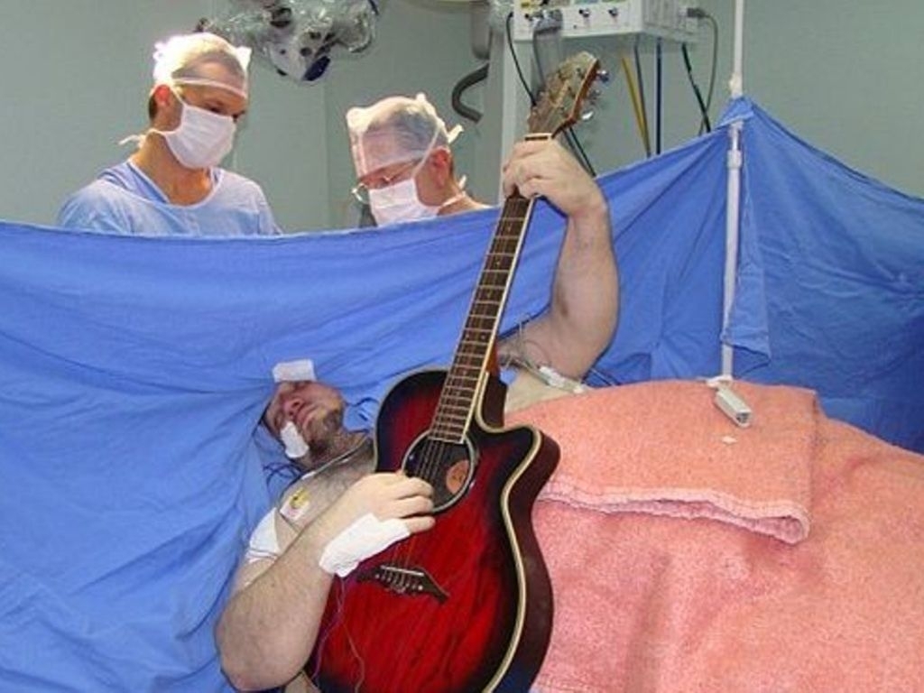 Hombre toca la guitarra mientras lo operan del cerebro