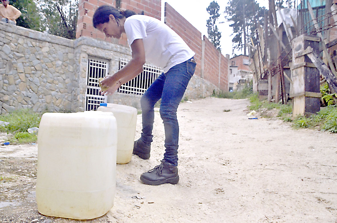 Mujeres cargan pipotes de  agua para solventar escasez
