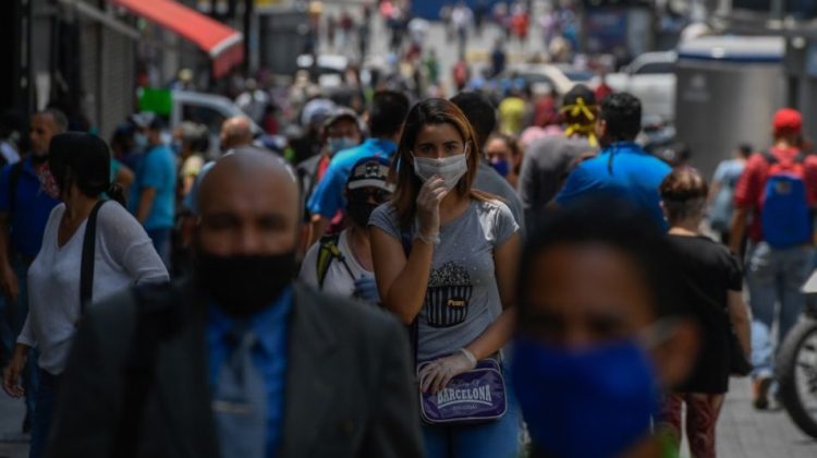 People wear face masks as they walk along Sabana Grande Boulevard after the government eased a nationwide lockdown as a preventive measure against the COVID-19 coronavirus, in Caracas, on June 3, 2020. - Banks, shoe stores and hairdressers reopened this week in Venezuela in a relaxation of the quarantine in force since mid-March due to the COVID-19 pandemic, coinciding with kilometer-long lines of vehicles waiting for turns at gasoline pumps. (Photo by Federico PARRA / AFP)