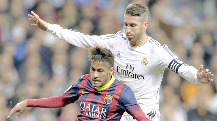 FC Barcelona's Neymar from Brazil, left is pressured by Real Madrid's Sergio Ramos during a Spanish La Liga soccer match at the Santiago Bernabeu stadium in Madrid, Sunday March 23, 2014. (AP Photo/Paul White)