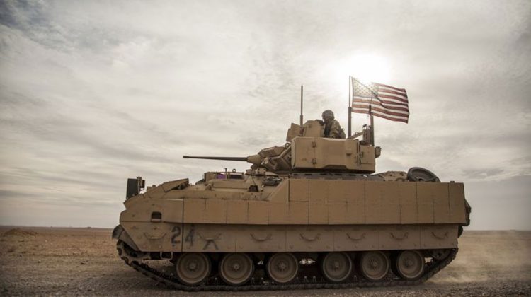 FILE - American soldiers drive a Bradley fighting vehicle during a joint exercise with Syrian Democratic Forces at the countryside of Deir Ezzor in northeastern Syria, Dec. 8, 2021. President Joe Biden said on Jan. 4, 2023, that's he's weighing sending Bradley Fighting Vehicles to help Ukraine in its effort to combat Russia's ongoing invasion. (AP Photo/Baderkhan Ahmad, File)