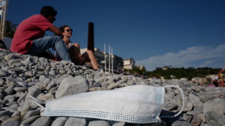 (FILES) In this file photo taken on May 22, 2020 A face mask lies on the newly re-open beach of Nice, French Riviera, after weeks of closure as part of the measures to curb the spread of the COVID-19 disease. - France's Prime Minister Jean Castex announced on June 16, 2021 that masks will be no longer compulsory outside in France from June 17, 2021. (Photo by VALERY HACHE / AFP)