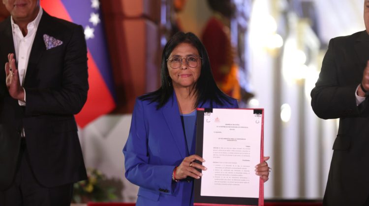 La presidenta encargada de Venezuela, Delcy Rodríguez, sostiene el documento de la ley de amnistía este jueves, en Caracas (Venezuela). EFE/ Ronald Pena R