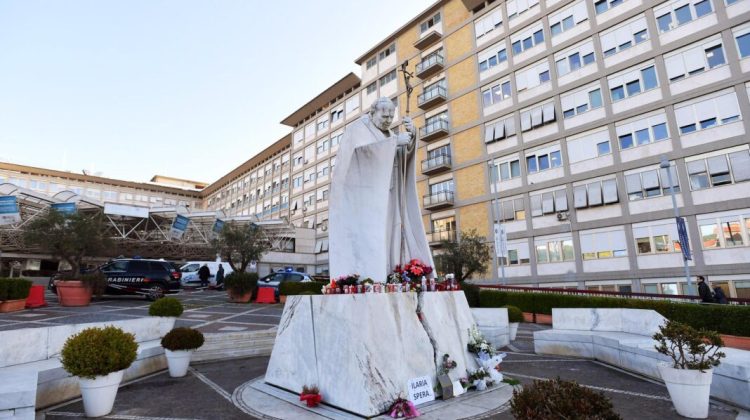 ROME (Italy), 21/02/2025.- Flowers and candles lay at the foot of a statue of Pope St. John Paul II outside Gemelli University Hospital, where Pope Francis is hospitalized for bronchitis treatment, in Rome, Italy, 21 February 2025. Pope Francis was hospitalized on 14 February due to a respiratory tract infection. (Papa, Italia, Roma) EFE/EPA/FABIO CIMAGLIA
