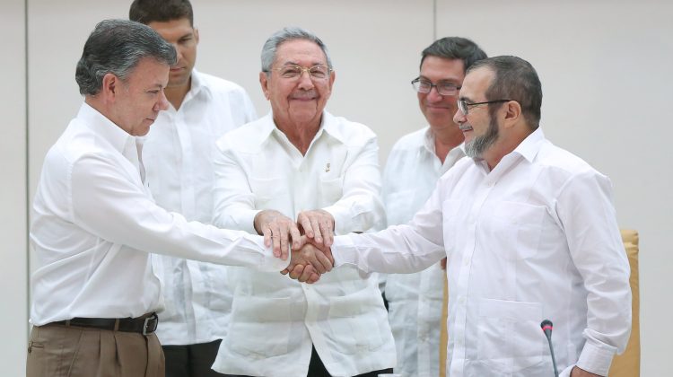 Cuba's President Raul Castro (C) stands as Colombia's President Juan Manuel Santos (L) and FARC rebel leader Rodrigo Londono, better known by the nom de guerre Timochenko, shake hands in Havana