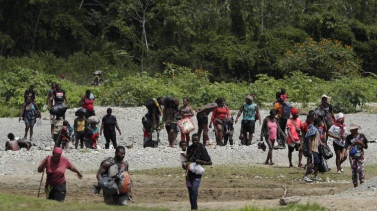 Migrants cross the Tuquesa River after a trip on foot through the jungle to Bajo Chiquito, Darien province, Panama, Wednesday, Feb. 10, 2021. Panama reopened its border in late January and ever since groups have been walking out of the dense Darien jungle that divides Panama and Colombia. (AP Photo/Arnulfo Franco)