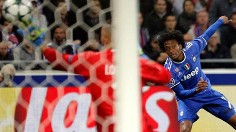 Juventus' Juan Cuadrado, right, shoots to score his team's opening goal during the Champions League Group H soccer match against Lyon, Tuesday Oct. 18, 2016, in Lyon, central France. (AP Photo/Laurent Cipriani) France Soccer Champions League