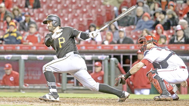 Pittsburgh Pirates' Francisco Cervelli hits a RBI single as Cincinnati Reds catcher Devin Mesoraco, right, looks on in the fifth inning of a baseball game, Friday, April 8, 2016, in Cincinnati. (AP Photo/John Minchillo)