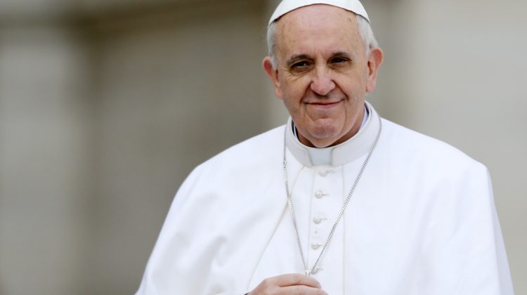 El papa Francisco toca su crucifijo mientras lo conducen a través de la multitud durante su audiencia general inaugural, en la Plaza de San Pedro, en el Vaticano, el miércoles 27 de marzo de 2013. Francisco pidió el miércoles que se ponga fin a la violencia y los saqueos relacionados con el golpe de estado del fin de semana en la República Centroafricana, en su primera apelación de ese tipo por la paz desde que se convirtió en papa. (AP foto/Andrew Medichini)