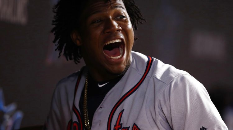 Atlanta Braves' Ronald Acuna Jr. celebrates in the dugout after scoring during the eighth inning of a baseball game against the Miami Marlins, Saturday, Aug. 10, 2019, in Miami. (AP Photo/Brynn Anderson)