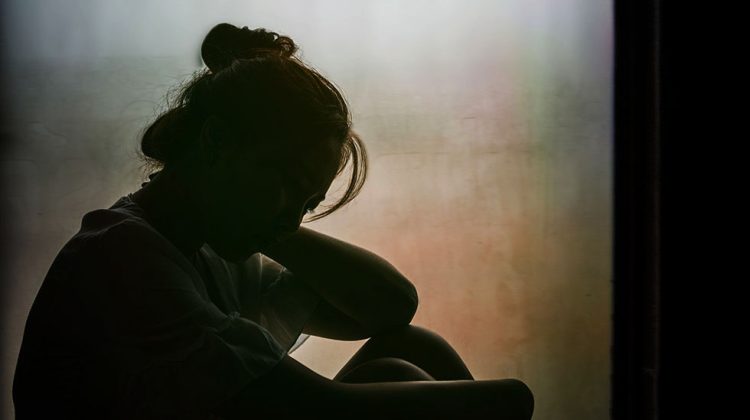 Vintage filtered on silhouette of depressed girl sitting on the