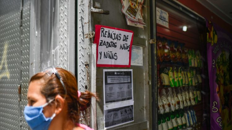 An employee stands outside a shoe shop now selling food, due to the COVID-19 coronavirus pandemic, at Sabana Grande Boulevard in Caracas on July 15, 2020. - The COVID-19 pandemic, which reached Venezuela in mid-March and has infected some 10,000 people, according to official figures, forced the closure of 90% of the businesses in the Caribbean country, according to the private company Consecomercio. Only supermarkets, pharmacies and other businesses considered "essential" by the socialist government are exempted from the national quarantine, which has been tightened in Caracas due to the spread of the virus. (Photo by Federico PARRA / AFP)