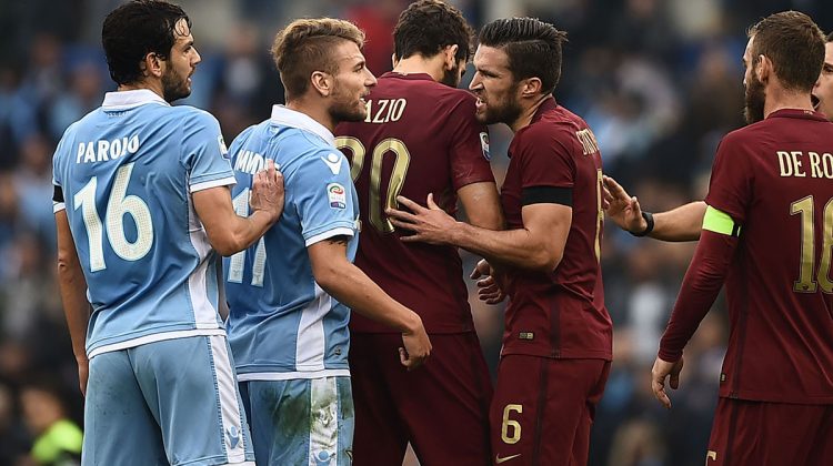 Lazio's midfielder from Italy Marco Parolo (L) and Lazio's forward from Italy Ciro Immobile (2ndL) argue with Roma's defender from Argentina Federico Fazio (C), Roma's midfielder from Netherlands Kevin Strootman (6) and Roma's midfielder from Italy Daniele De Rossi as Roma's defender from Greece Kostas Manolas (bottom) lies on the ground during the Italian Serie A football match SS Lazio vs AS Roma on December 4, 2016 at the Olympic stadium in Rome.  / AFP / FILIPPO MONTEFORTE        (Photo credit should read FILIPPO MONTEFORTE/AFP/Getty Images)