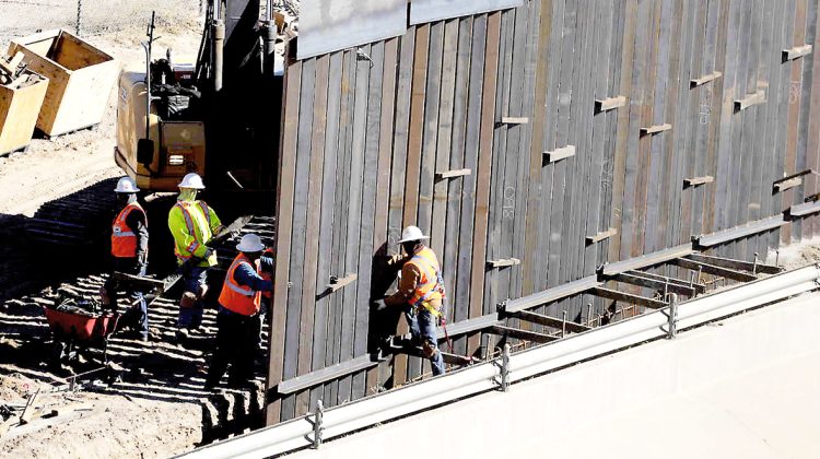 En esta fotografía del martes 22 de enero de 2019 trabajadores colocan secciones de un muro de metal cerca del centro de El Paso. (AP Foto/Eric Gay)