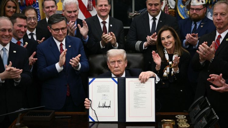 US President Donald Trump shows the signed bill package to re-open the federal government in the Oval Office of the White House in Washington, DC, on November 12, 2025. Congress on Wednesday ended the longest government shutdown in US history, 43 days that paralyzed Washington and left hundreds of thousands of workers unpaid while Republicans and Democrats played a high-stakes blame game. The Republican-led House of Representatives voted largely along party lines to approve a Senate-passed package that will reopen federal departments and agencies, as many Democrats fume over what they see as a capitulation by party leaders. (Photo by Brendan SMIALOWSKI / AFP) (Photo by BRENDAN SMIALOWSKI/AFP via Getty Images)